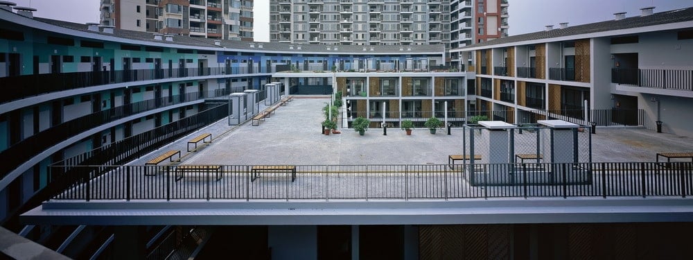 This is a view of the rooftop area of the central structure with concrete walkways and various potted plants bordered with wrought iron railing.