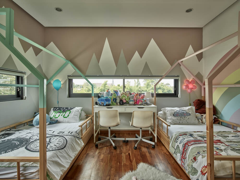 This is the children's bedroom with a couple of canopy beds and a study area in the middle.