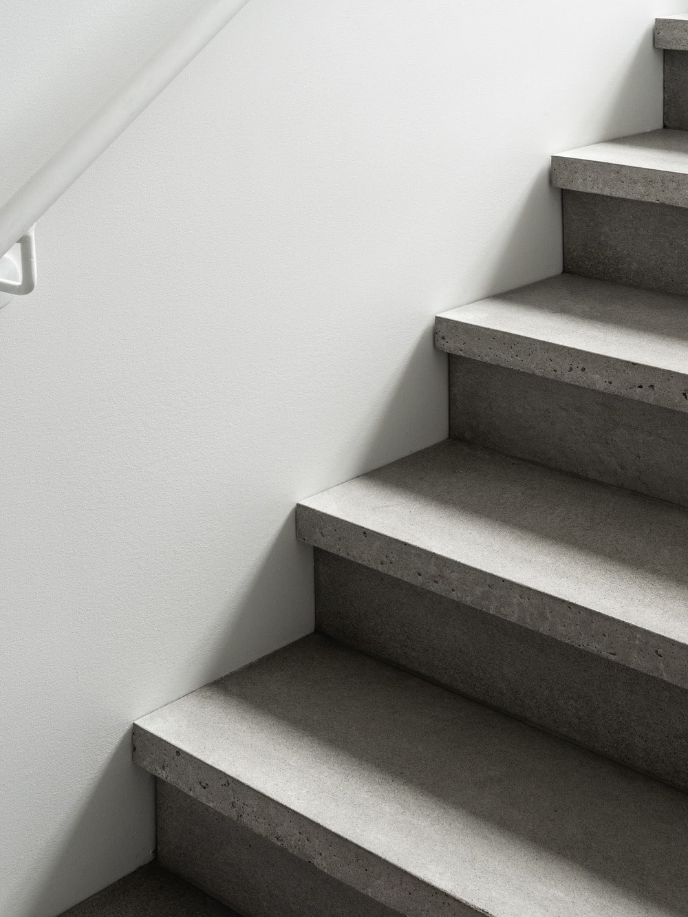 This is a closer look at the concrete steps of the stairs contrasted by the bright walls.