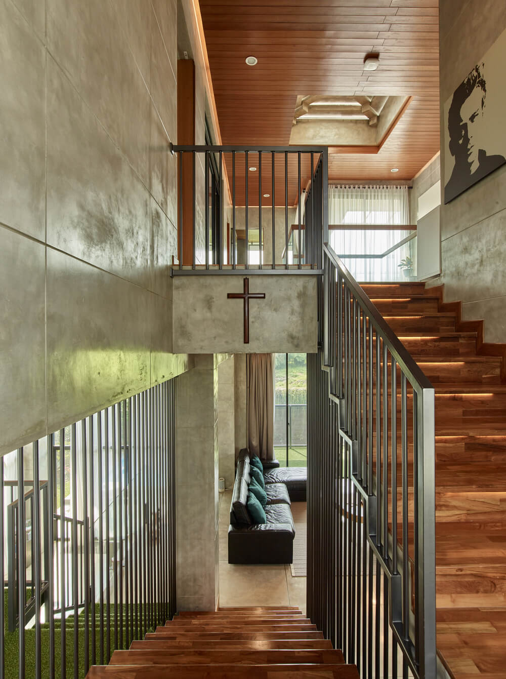 The staircase has wooden steps that stand out against the black railings and concrete walls.