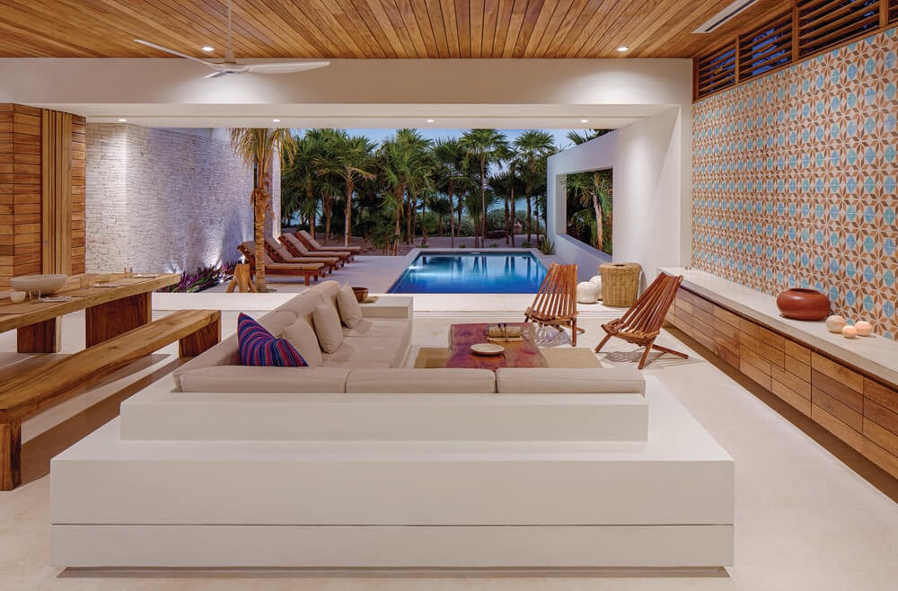 This is a close look at the living room of the house that has a large L-shaped sectional sofa under a wooden shiplap ceiling.