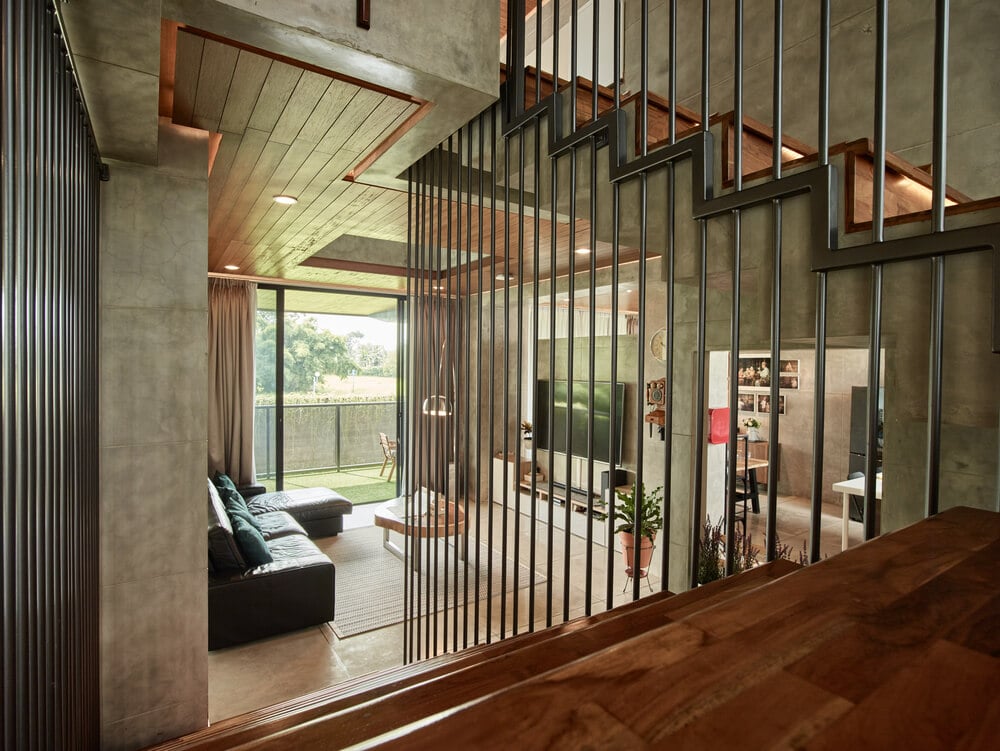 This is a view of the living room area from the vantage of the staircase lined with railings on the side.
