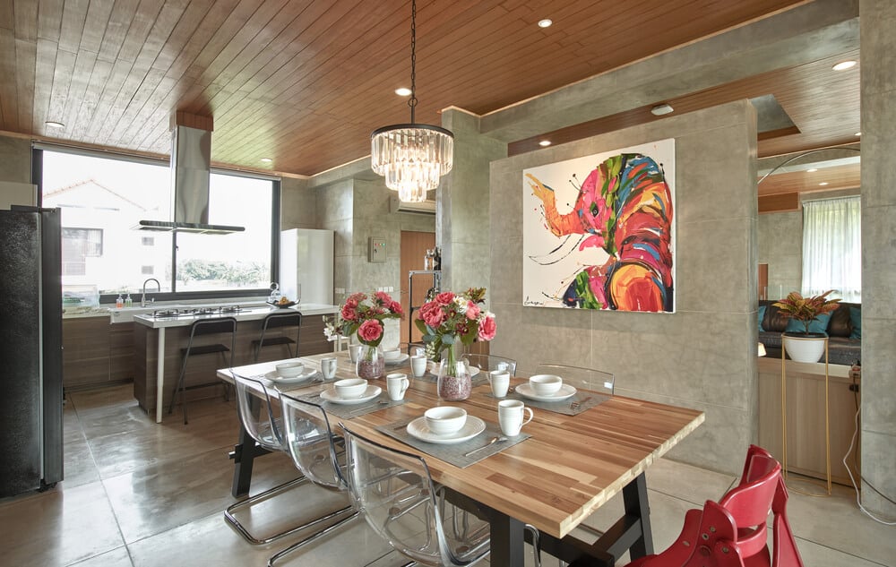 This is a close look at the dining area with its wood-top rectangular dining table adorned with a colorful wall-mounted artwork on the side.
