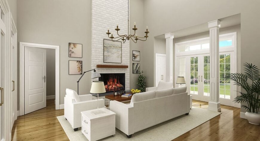 The living room has light gray seats and a fireplace fitted on the white brick accent wall.