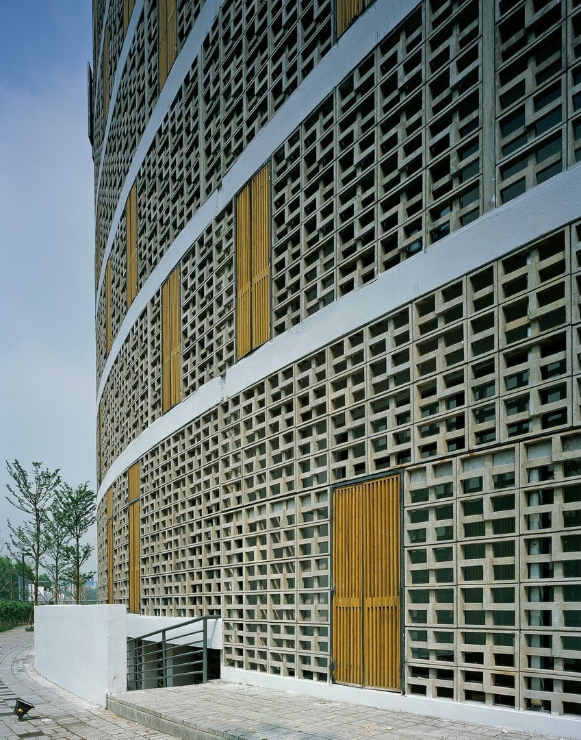 This is a close look at the side of the building showcasing the patterned concrete wall panels, windows and a set of steps leading to the basement floors.