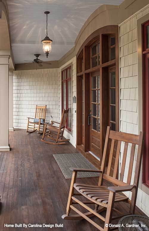 The covered porch is furnished with wooden rocking chairs and a textured rug.The covered porch is furnished with wooden rocking chairs and a textured rug.