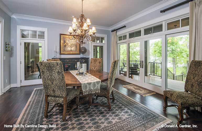 Dining room with an ornate chandelier, a round dining set, and direct access to the covered porch.