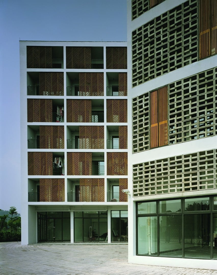 This is a close look at the other structures of the collective housing that has similar concrete wall panels and windows along with glass walls.