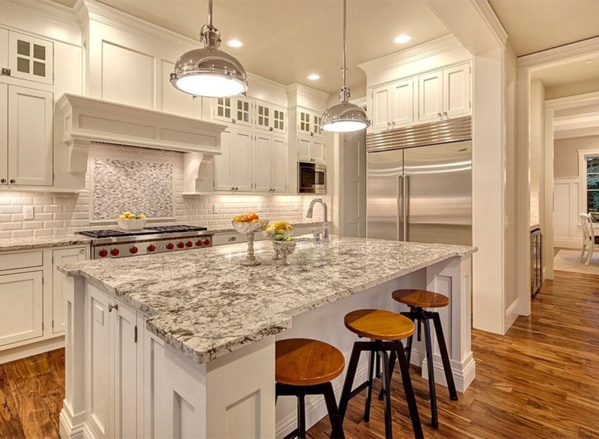 A couple of chrome pendants along with round bar stools complement the breakfast island.