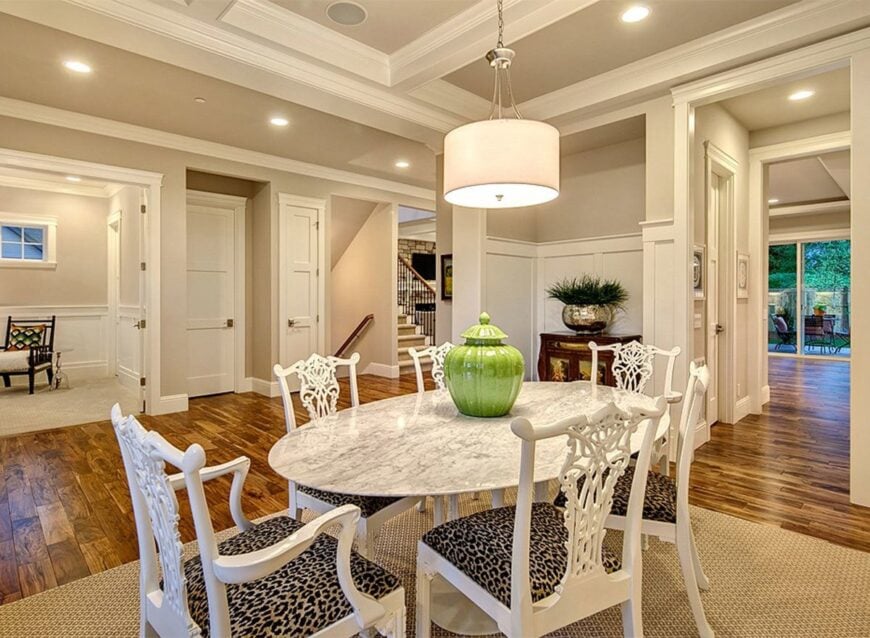 Recessed ceiling lights and a drum chandelier illuminate the dining room.