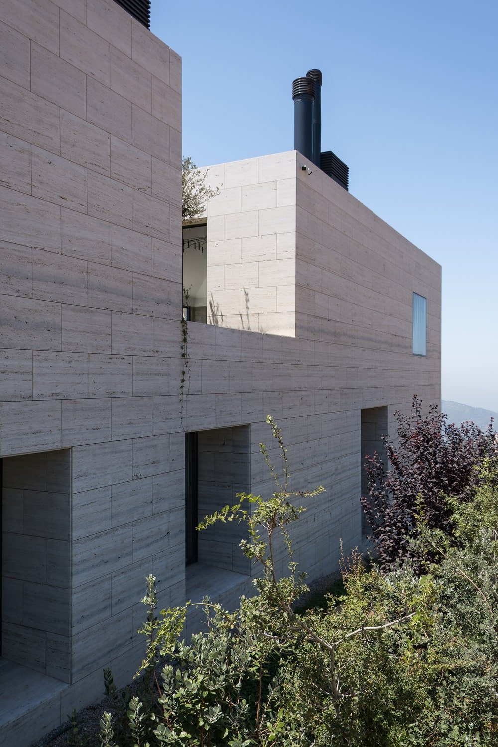 This is an exterior view of the house showcasing its unique tone and the modern fireplaces at the top.