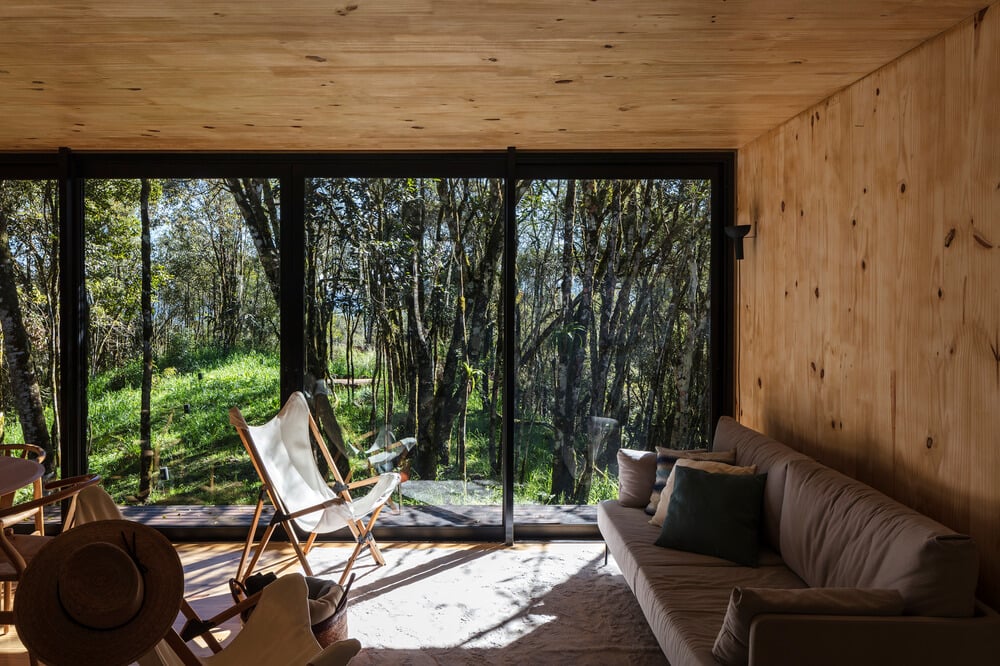 The living room has a large gray sofa across from the folding chairs.