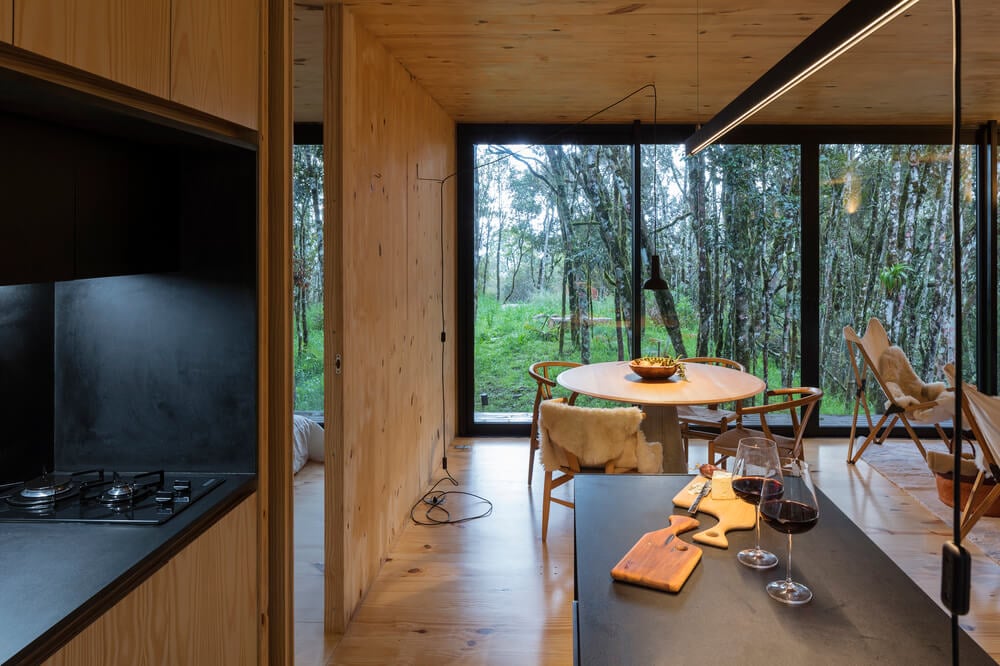 A few steps from the living room chairs is the dining area that has a round dining table by the large window.