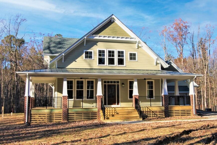 Front exterior view showing the wraparound porch bordered by brick columns.