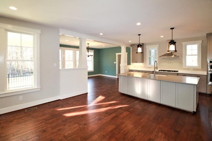 Kitchen with taupe cabinetry, built-in cooktop, and a large prep island fitted with a sink.