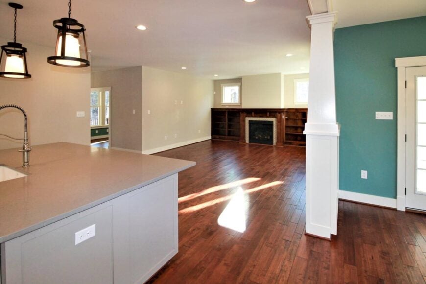 The living room has wooden built-ins, a fireplace, and picture windows.