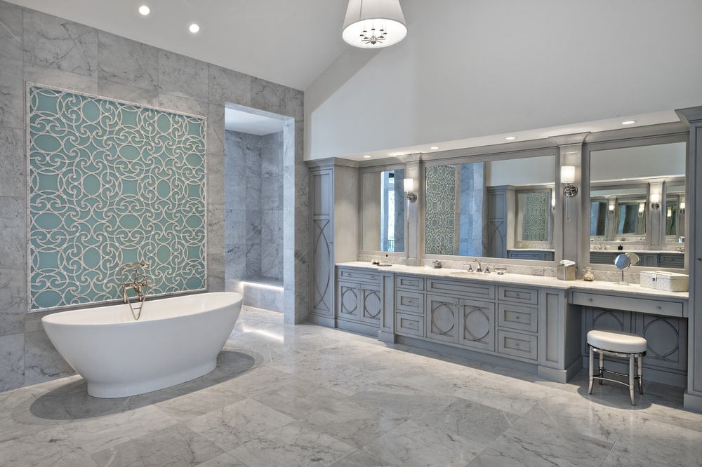 This is the spacious primary bathroom with a freestanding bathtub and two-sink vanity topped with a tall ceiling.