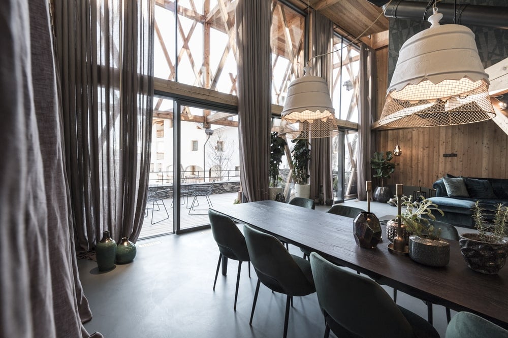 Beyond the kitchen is this dining area that has a tall ceiling and dark wooden dining set brightened by the natural lights.