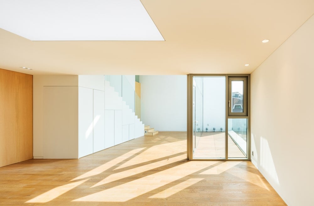 This is a spacious area with hardwood flooring, a glass divider and a skylight in the middle.