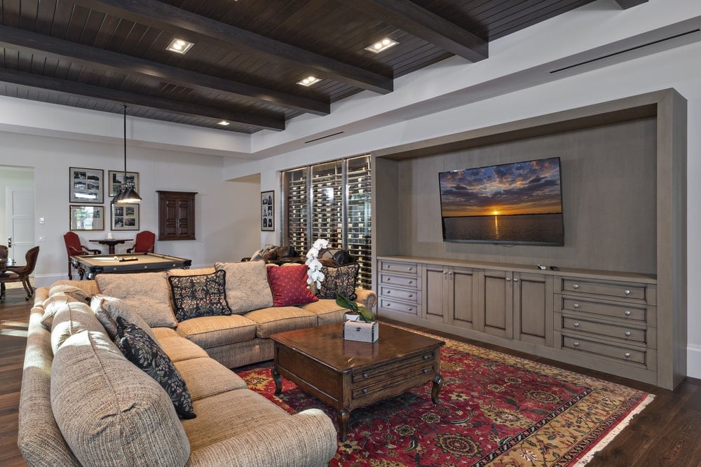 The family room has a large L-shaped sectional sofa and wooden coffee table across from the wall-mounted TV.