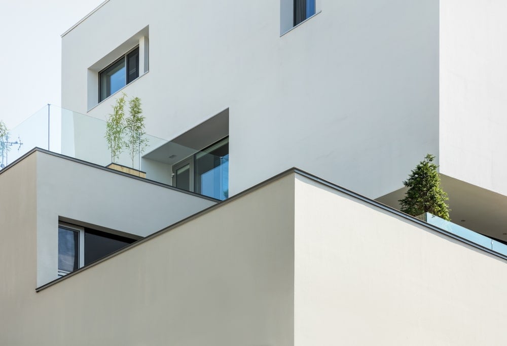 This is an exterior look at the building showcasing the balcony of the upper floor along with various windows.