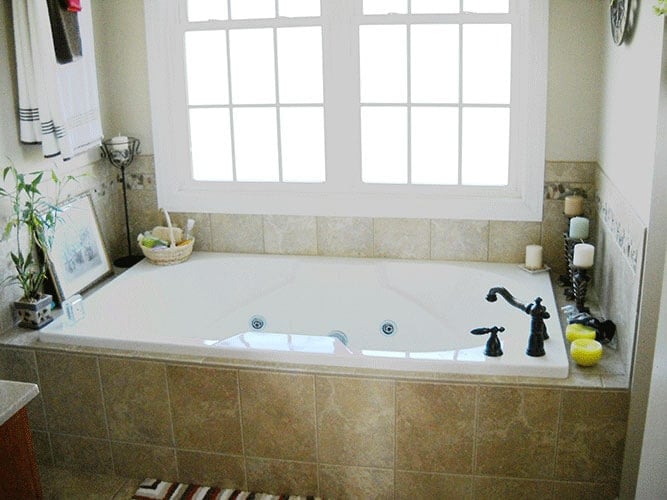 Inviting Bathroom with Sunlit Bathtub and Black Accents