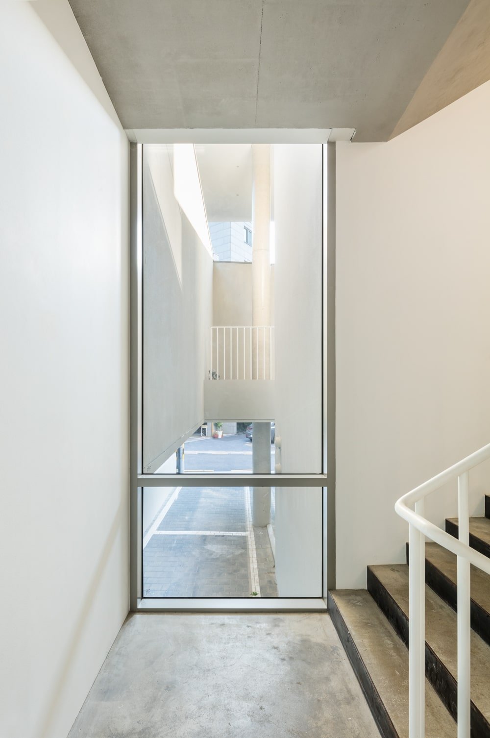 This is a close look at a glass wall by the stairs with a view of the parking below.