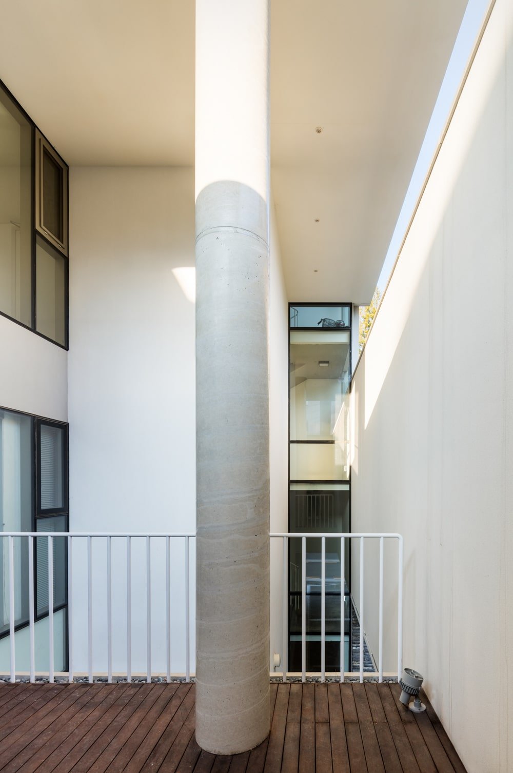 This is an indoor balcony within the house with metal railings and a view of the glass wall on the far side.
