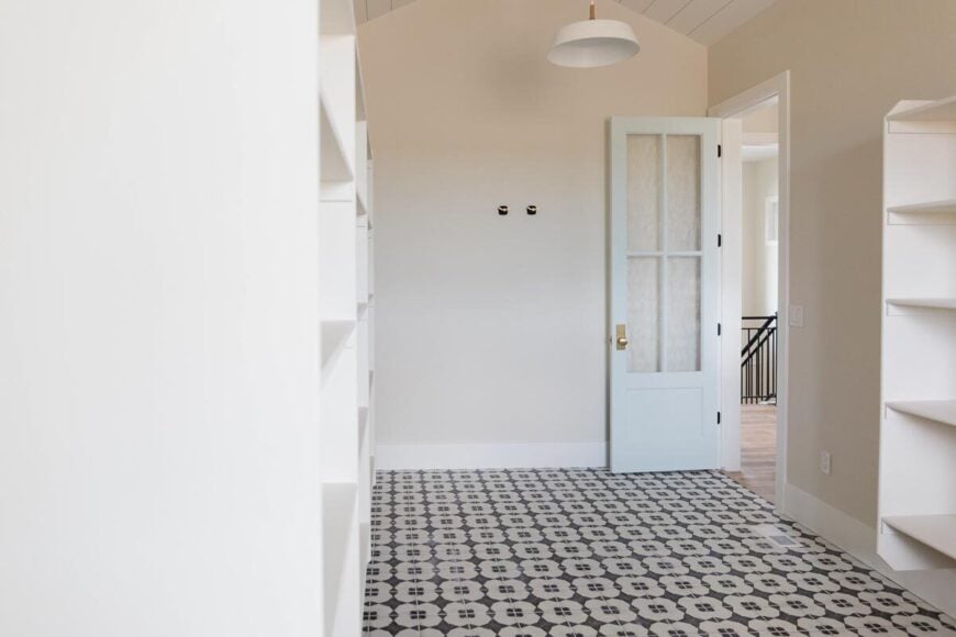 Spacious walk-in pantry with vaulted ceiling and decorative tile flooring.