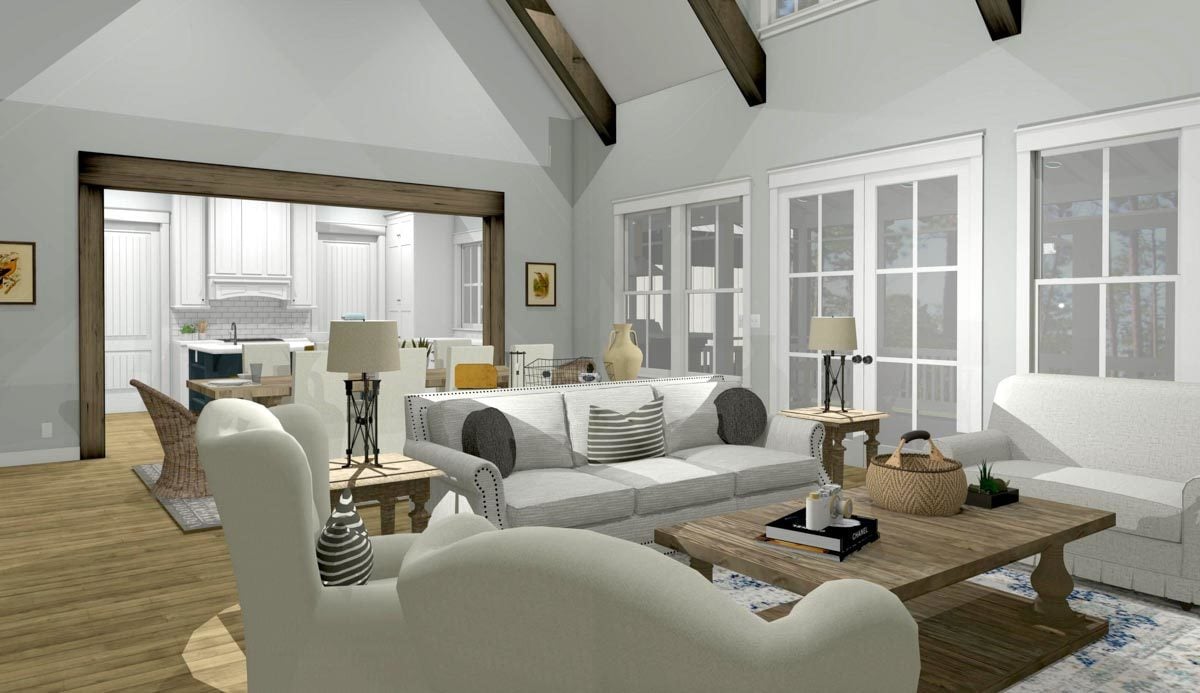 Living room with white sofas, wingback chairs, and a rustic coffee table over a patterned area rug.