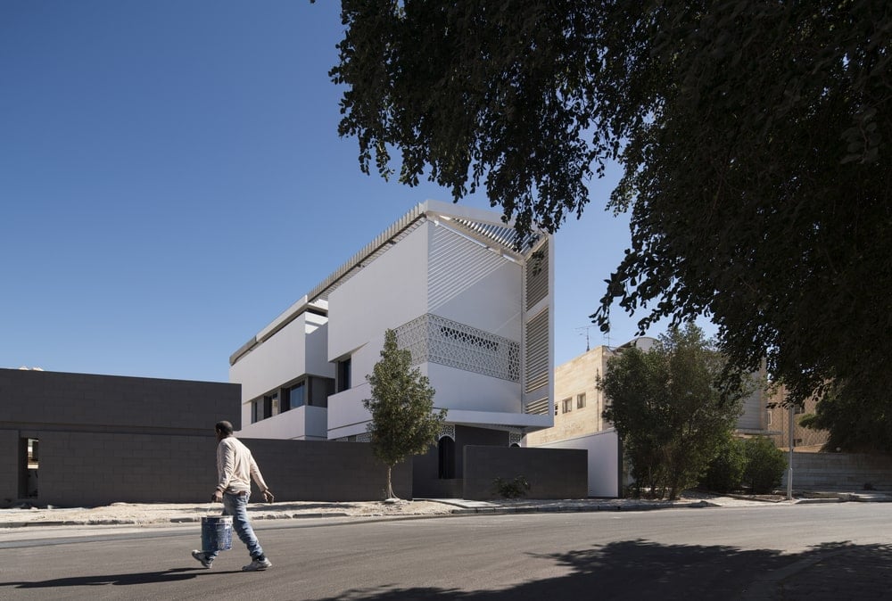 This is a view of the house from across the street showcasing the dark wall of the front and white exterior walls of the house.