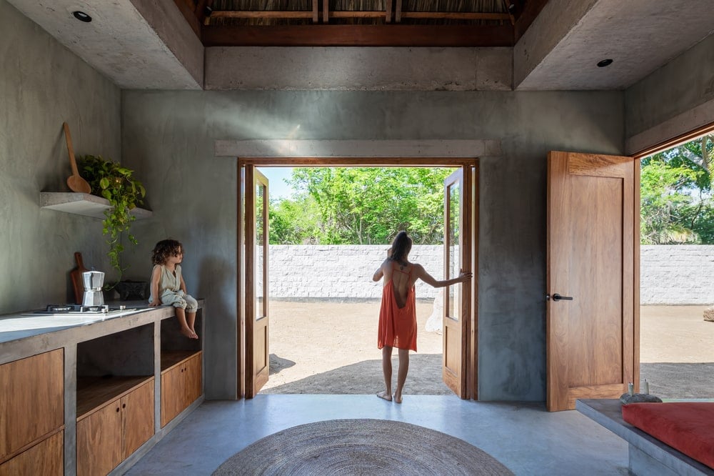 This is a look at the concrete counters and structure of the kitchen by the large open wall with foldable doors.