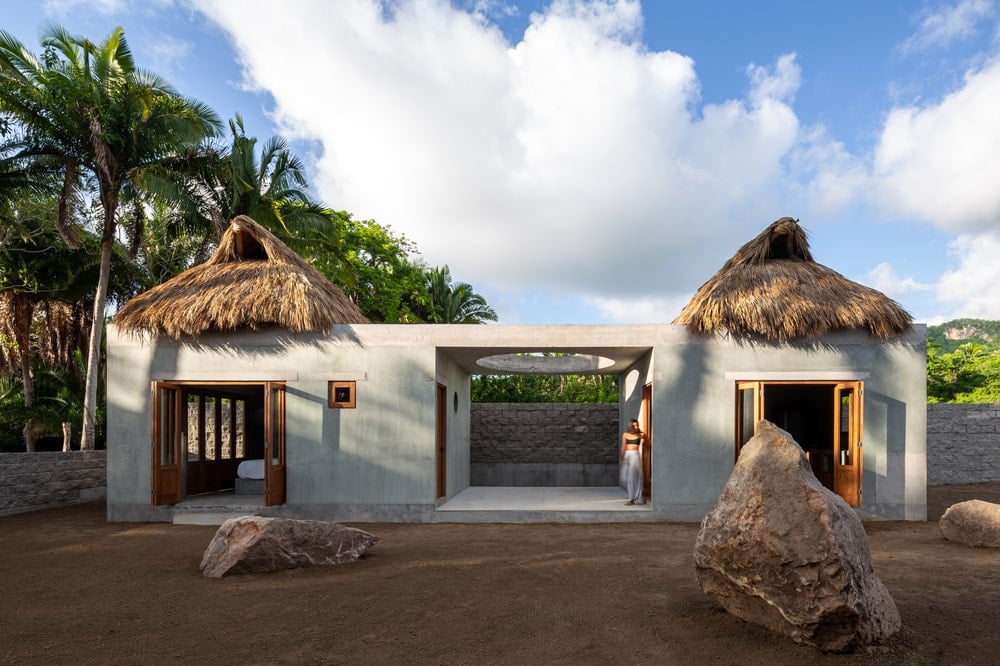 This is a view of the front of the house with decorative rocks and walls that open up to the landscape.