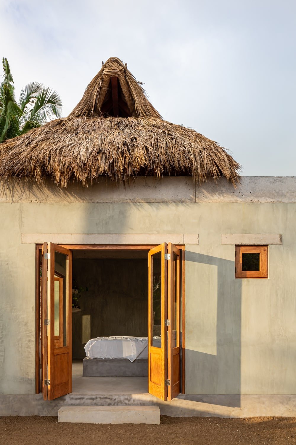 The concrete floor of the bedroom extends to the exterior and serve as a step to transition to the soil of the landscape.