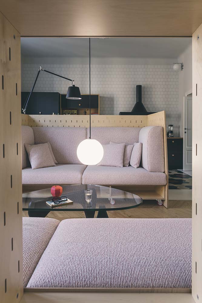 This is a close look at the living room area that has customized built-in sofas paired with a glass-top coffee table.