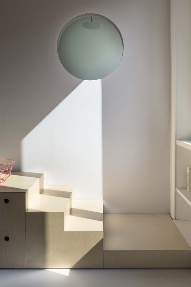 This is the bottom of the wooden set of steps topped with a large spherical pendant light.