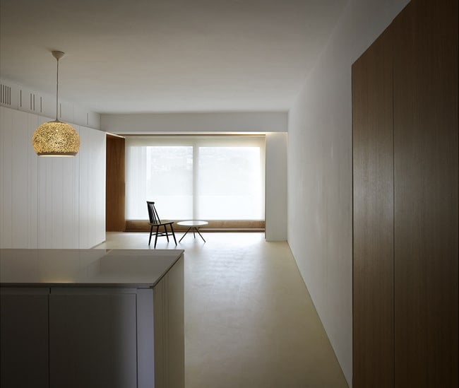 This is a view of the large room from the vantage of the kitchen island with a large glass wall on the far side.