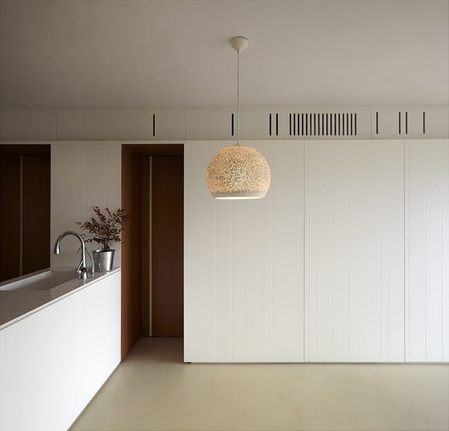 This is a look at the dining and living room beyond the kitchen peninsula that has a dome pendant light.