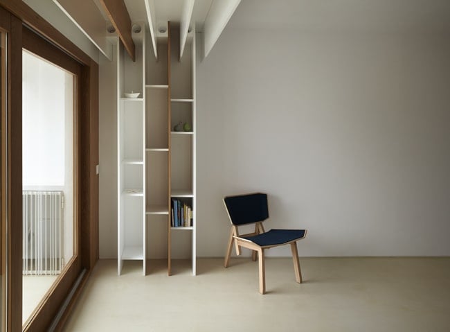 This is a close look at the wall by the large glass window that has built-in wooden bookshelves.