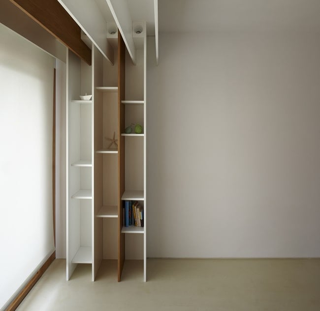 The built-in wooden bookshelves have a unique design that extends to the ceiling.
