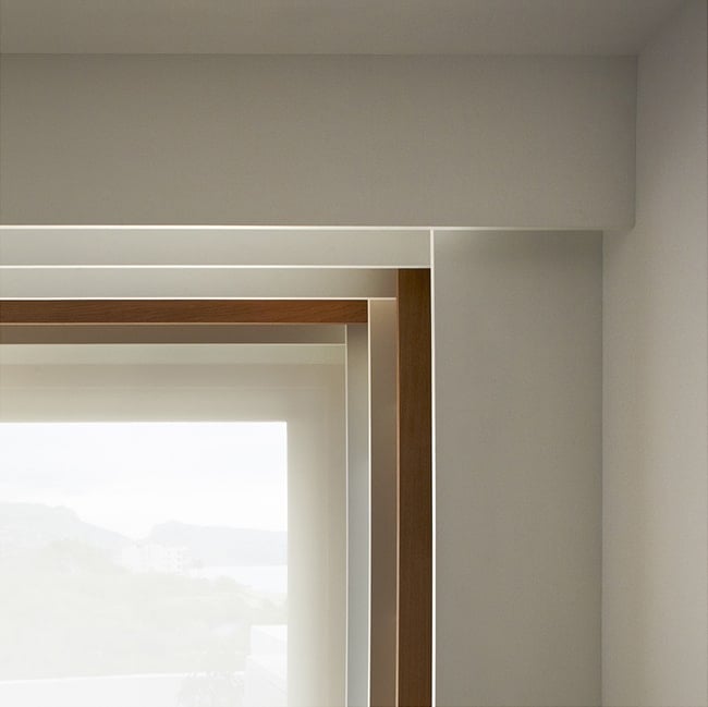 This is a side view of the upper corner of the built-in bookshelves with a few brown wooden panels to break the monotony.