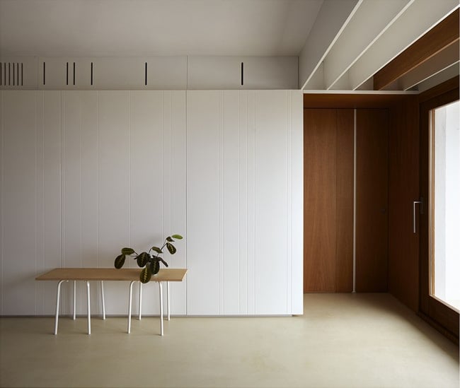 This is the white wall on the side of the large area with built-in cabinets topped with a white tray ceiling.
