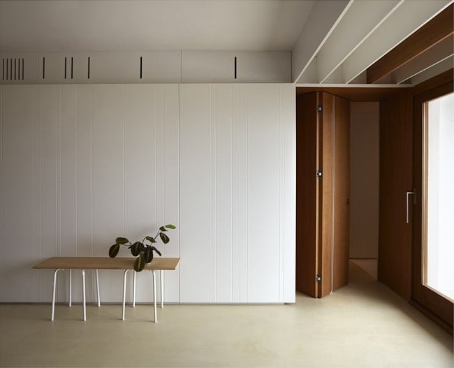 On the side of the large built-in cabinets is a set of wooden folding doors.