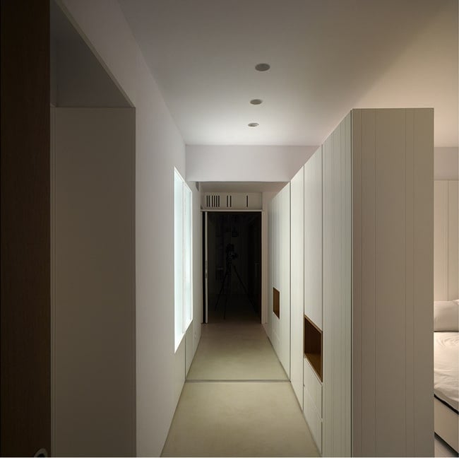 The white walls and white ceiling of the hallway are also complemented by the bright natural lights coming from the window.