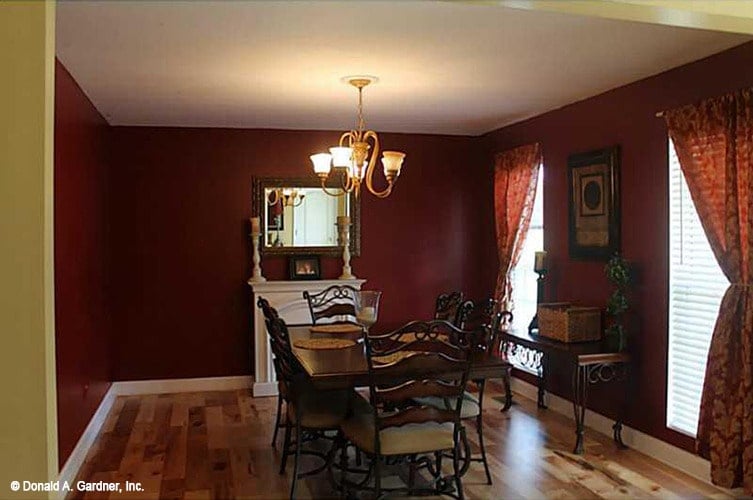 Formal dining room with red walls, a wooden dining set, and a matching buffet table.