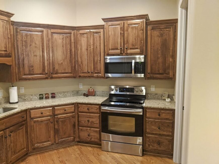 A closer look at the cooking range with a microwave suspended on top.