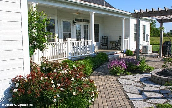 A closer look at the covered porch framed with white railings and columns.A closer look at the covered porch framed with white railings and columns.