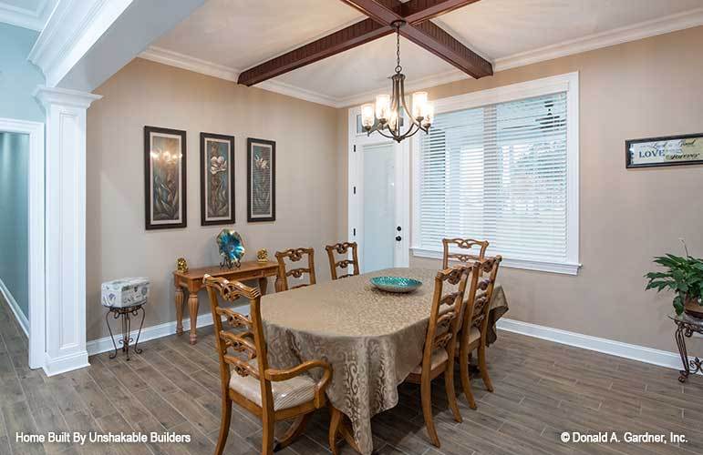 Formal dining room with an oval dining set and a wooden buffet table adorned with framed artworks.