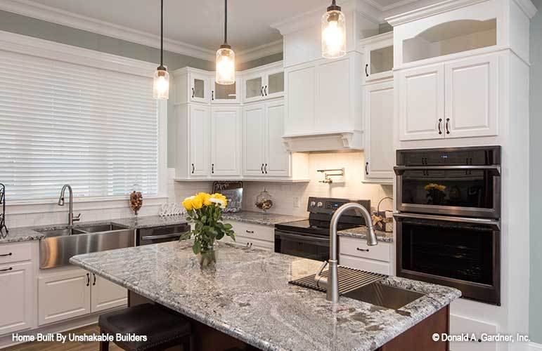 A closer look at the kitchen island illuminated by glass pendants.