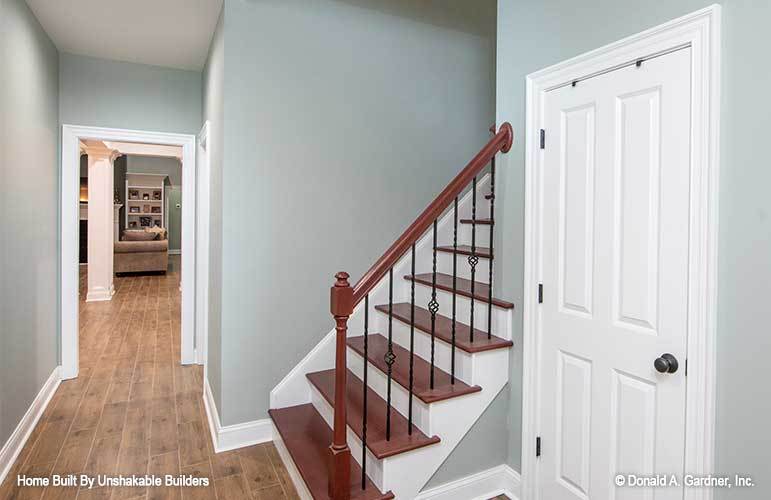 Staircase with ornate iron railings leading to the upstairs bonus room.